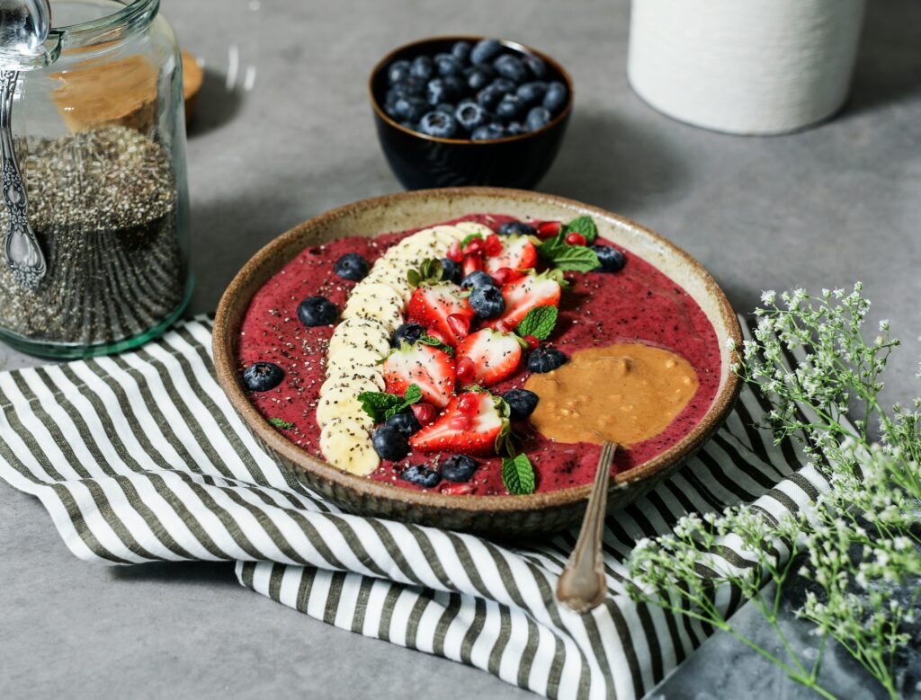 Berry smoothie bowl topped with banana, strawberries, and chia seeds, foods to lower blood pressure naturally