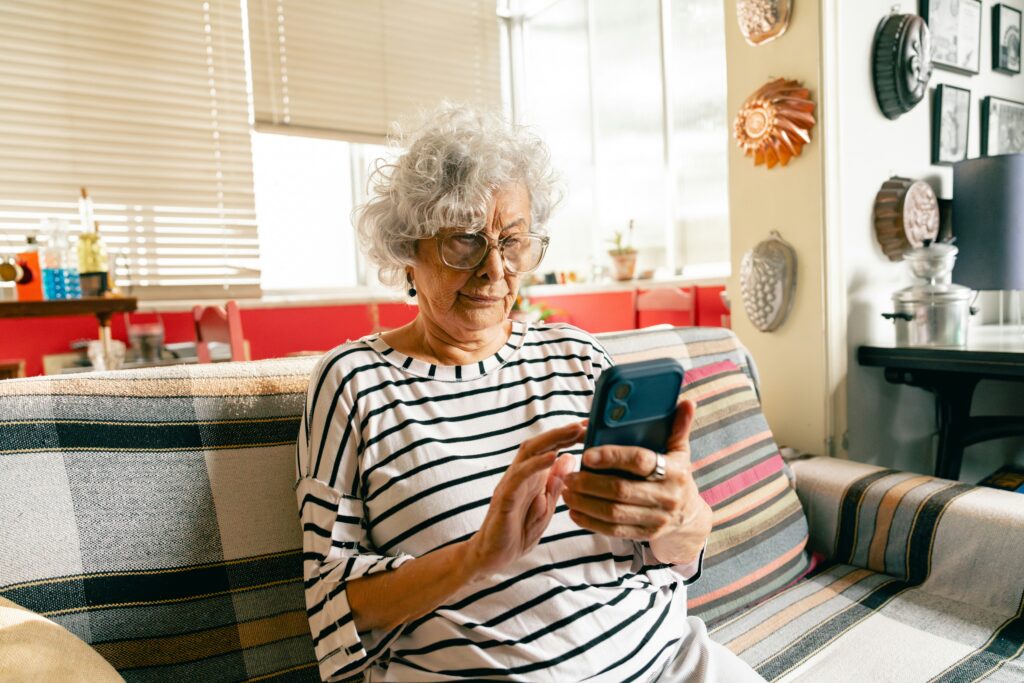 Older adult woman on her phone learning how to identify and avoid Medicare scam calls