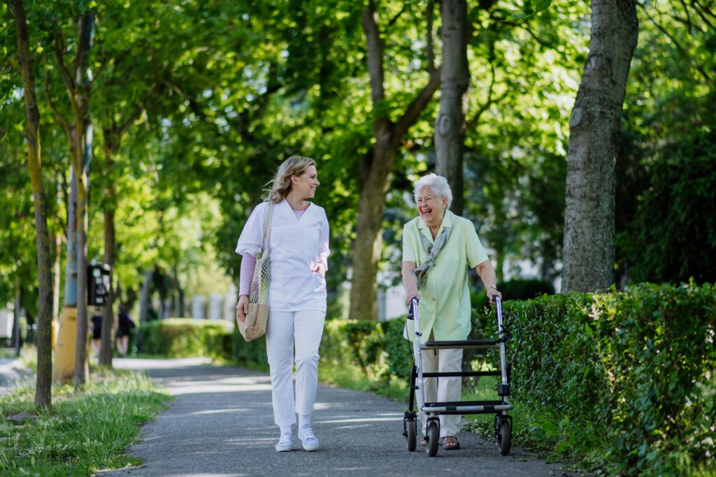 Care coordinator walking with a senior outdoors, an example of community health integration