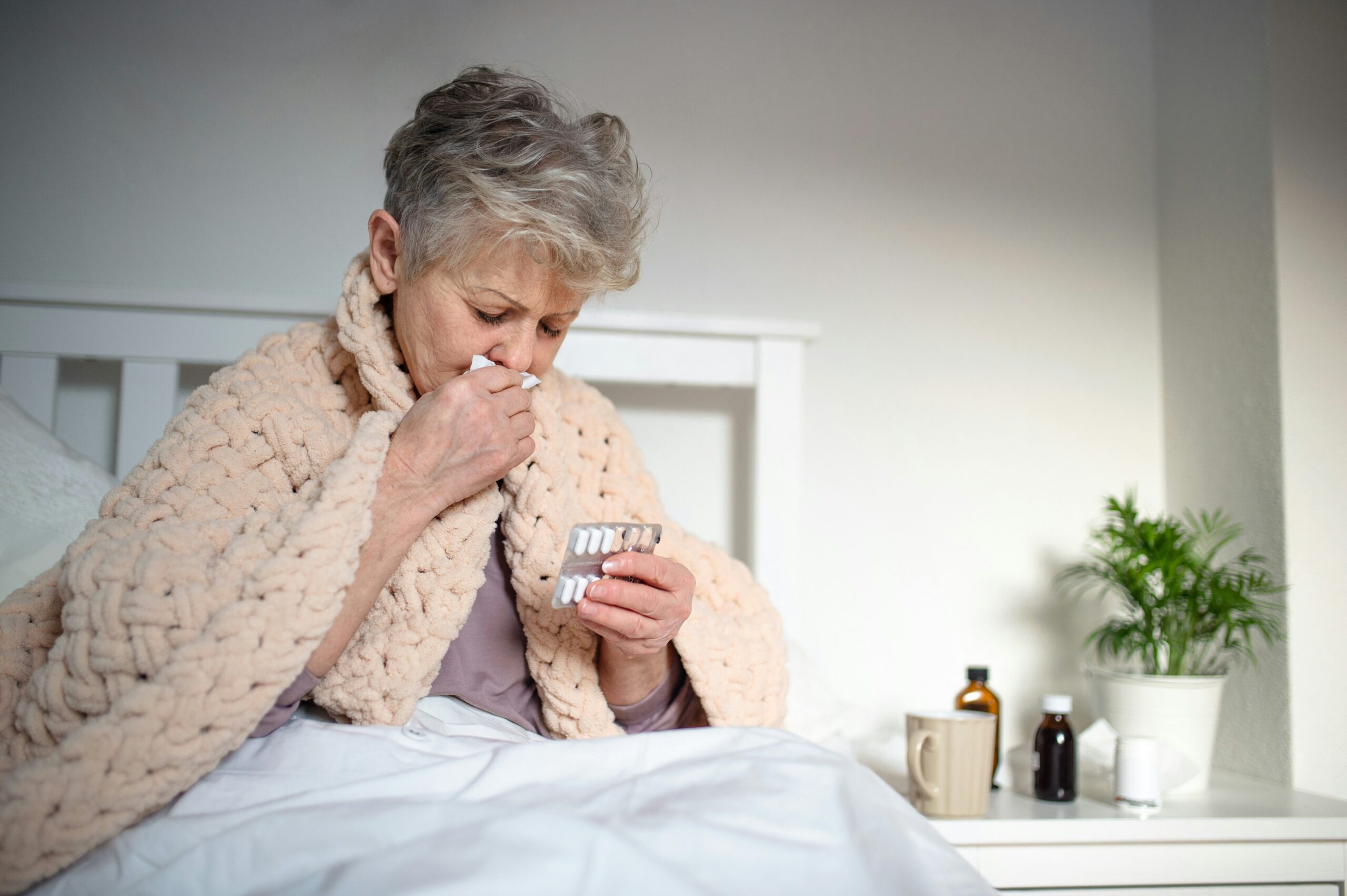 Older adult woman with COPD symptoms coughing at home showing how humidity worsens COPD