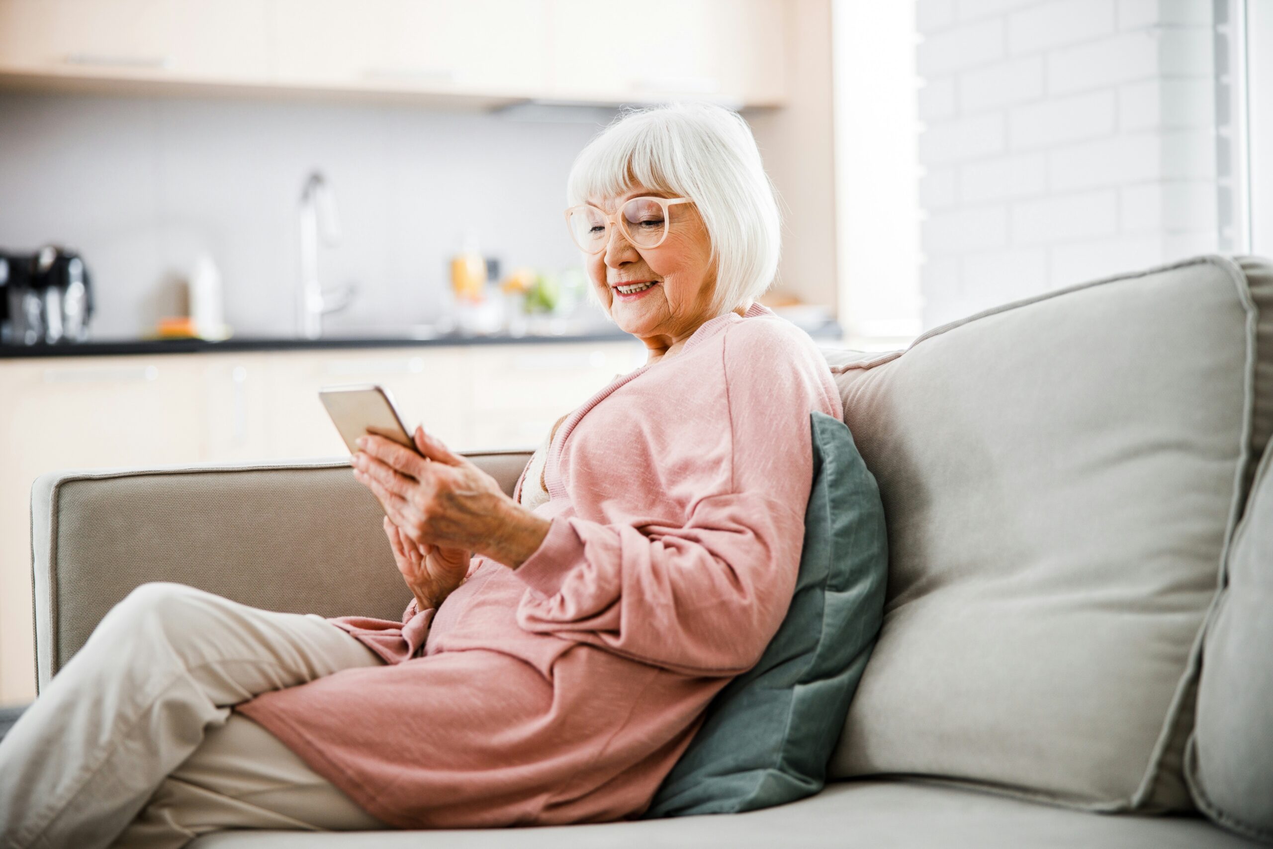 Senior woman reviewing her Medicare coverage on her phone at home