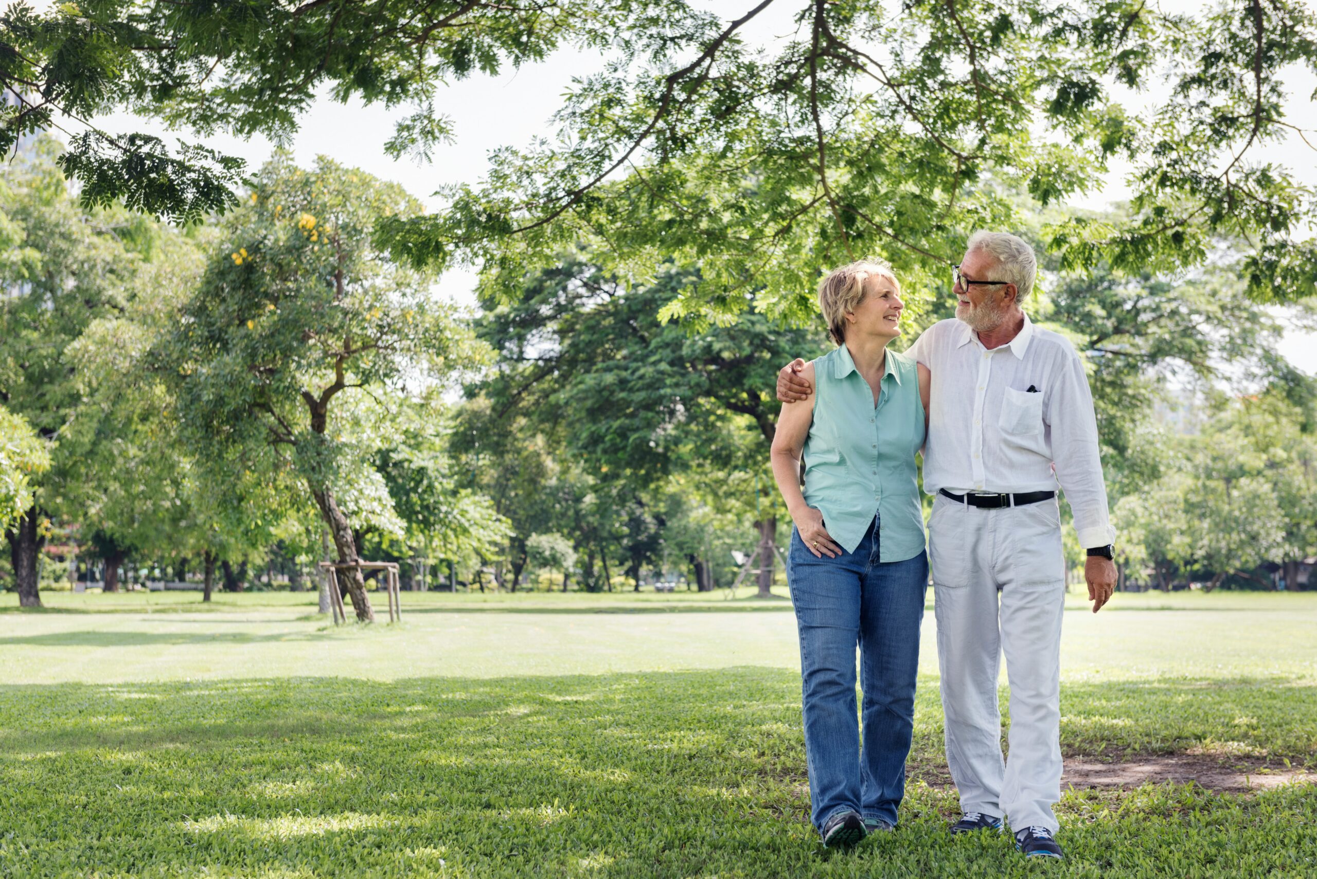 Senior couple walking together in a park, representing eligibility for Medicare Chronic Care Management