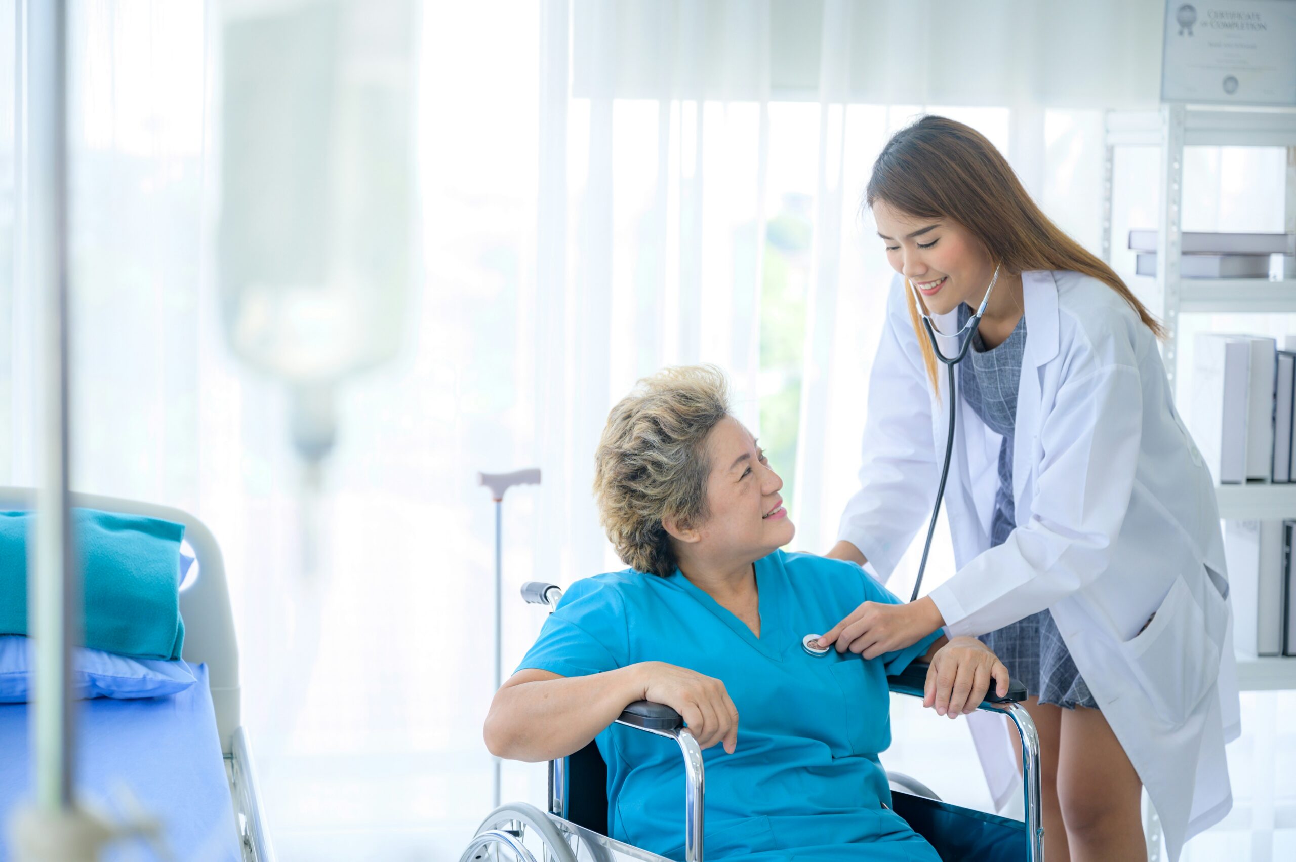 Doctor examining a senior patient in a wheelchair during a Medicare wellness visit