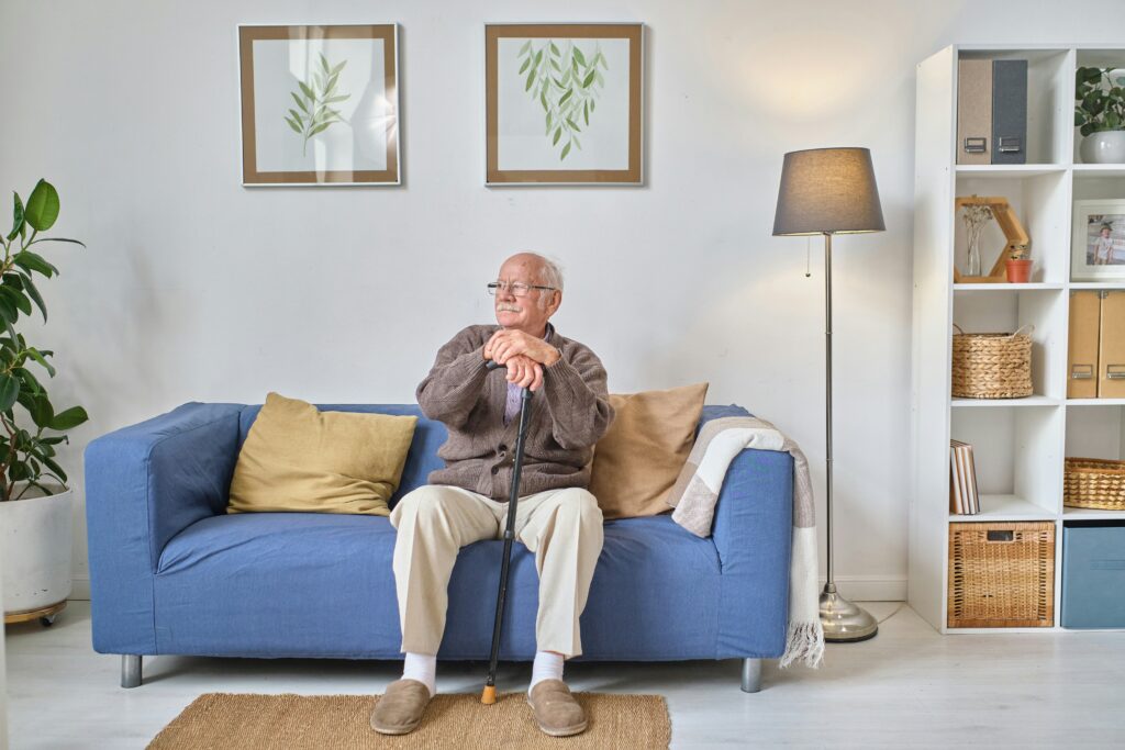 Senior man sitting thoughtfully at home, reflecting on his mental health and Medicare coverage options