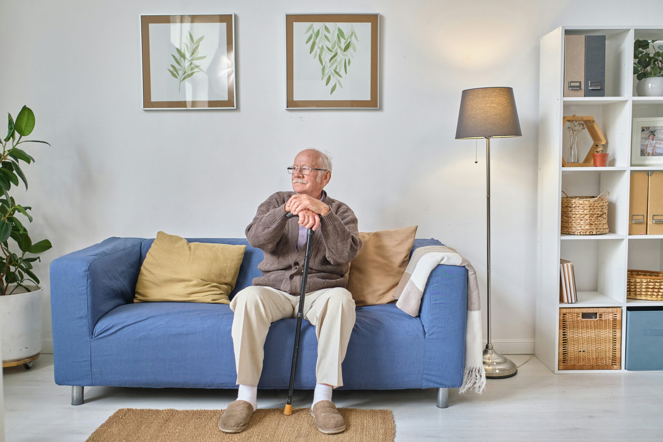 Senior man sitting thoughtfully at home, reflecting on his mental health and Medicare coverage options
